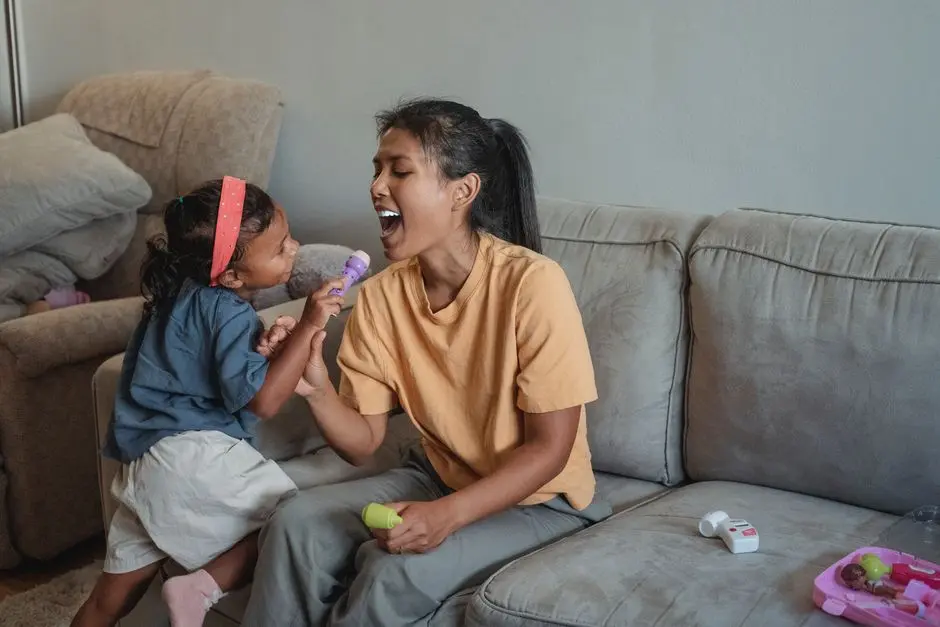 Seorang ibu bekerja tengah minum teh sambil bersantai di sofa, anak bermain di samping